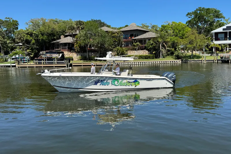 Slide: The Image of 2007 Pursuit 310 Center Console boat on a calm river near waterfront homes. - 38