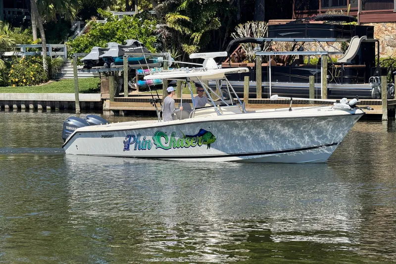 Slide: The Image of 2007 Pursuit 310 Center Console boat docked on a sunny waterfront. - 39