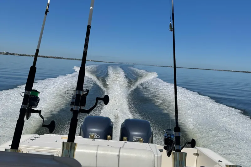 Slide: The Image of 2007 Pursuit 310 Center Console boat with fishing rods and twin engines on open water. - 40