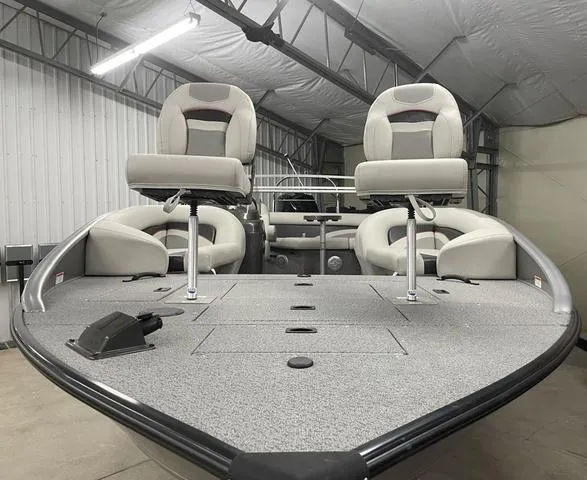 Slide: The Image of 2023 Lowe SD224 boat interior with swivel seats in a storage facility. - 10