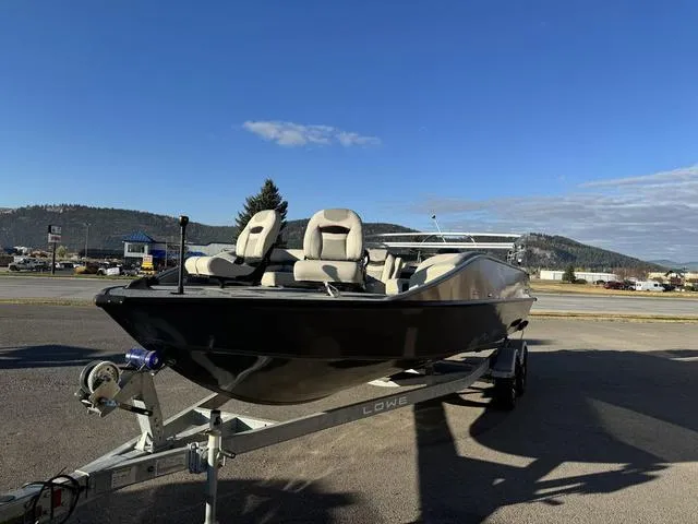 Slide: The Image of 2023 Lowe SD224 boat on trailer, parked outdoors under clear blue sky. - 4