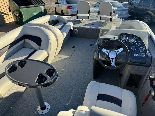 Slide: The Image of 2023 Lowe SD224 boat interior with seating, steering wheel, and cup holders. - 7