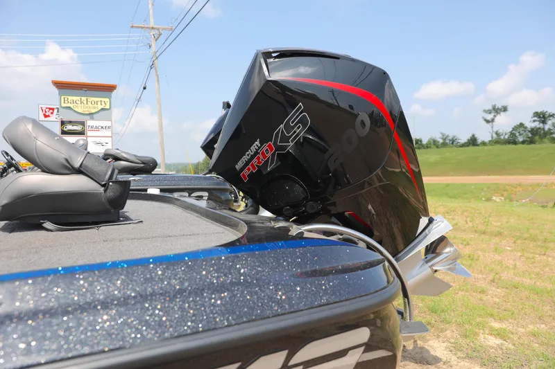 Slide: The Image of 2024 Nitro Z19 boat with powerful outboard motor, parked outdoors on a sunny day. - 13