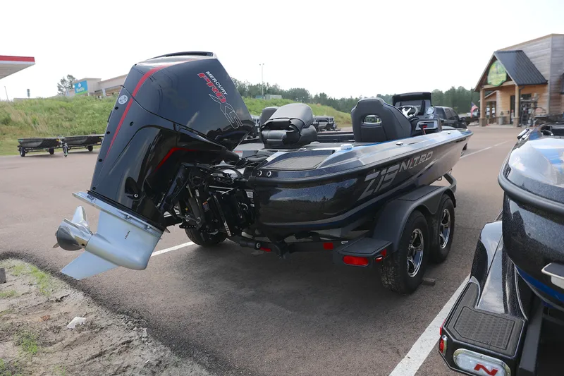 Slide: The Image of 2024 Nitro Z19 boat on trailer, parked in a lot near a gas station. - 3