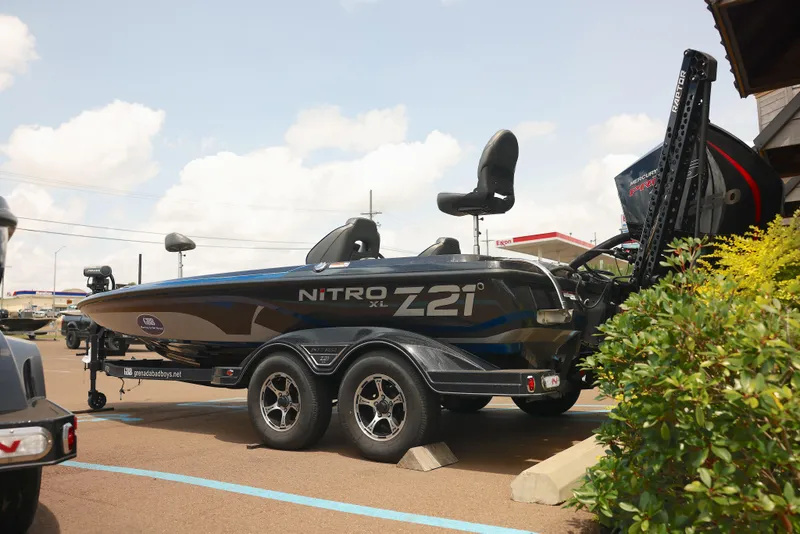 Slide: The Image of 2024 Nitro Z21 XL Pro boat on trailer, parked outdoors under a cloudy sky. - 6