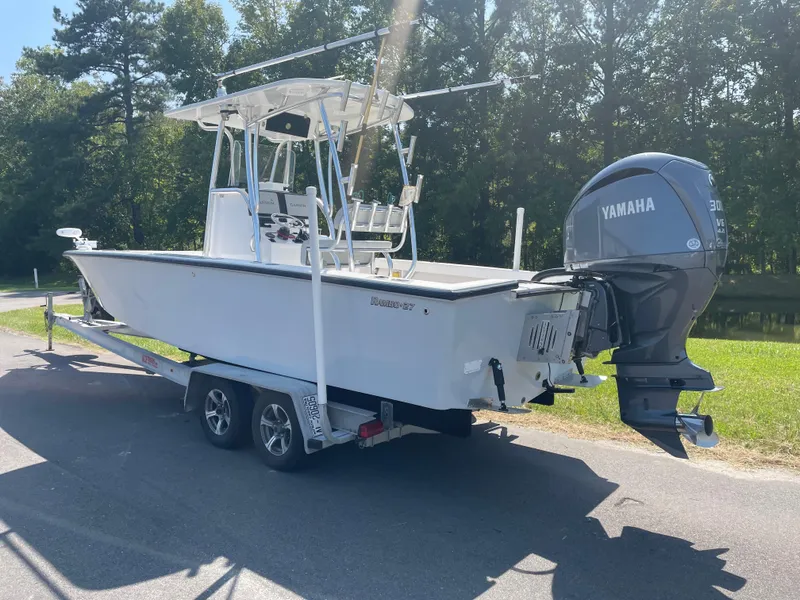 Slide: The Image of 2023 Rambo 27 boat with Yamaha 300 outboard motor, parked on a road. - 4