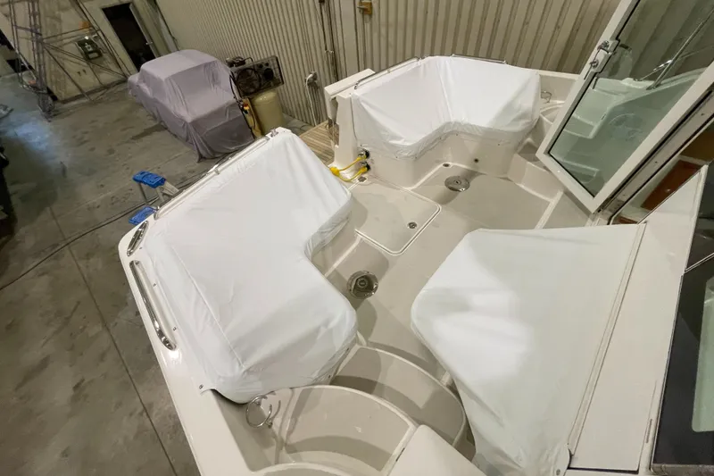 Slide: The Image of 2025 Back Cove 372 boat interior with covered seating in a workshop setting. - 19