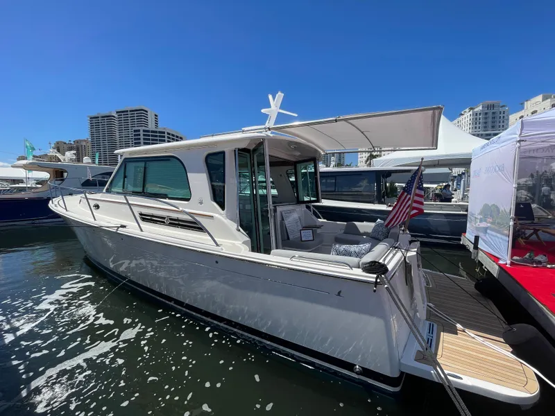 Slide: The Image of 2025 Back Cove 372 yacht docked, featuring sleek design and modern amenities under clear blue skies. - 2