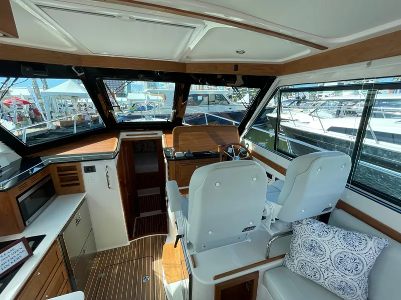 Slide: The Image of Interior of 2025 Back Cove 372 yacht with helm, seating, and wood accents. - 25