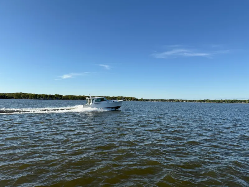 Slide: The Image of 2025 Back Cove 372 cruising on a sunny lake under clear blue skies. - 3