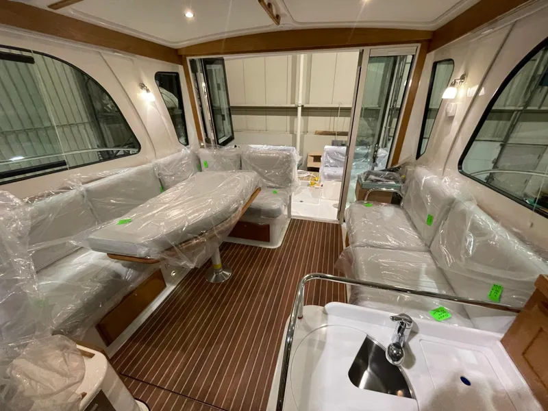 Slide: The Image of 2025 Back Cove 372 yacht interior with wrapped seating, wooden flooring, and modern amenities. - 30