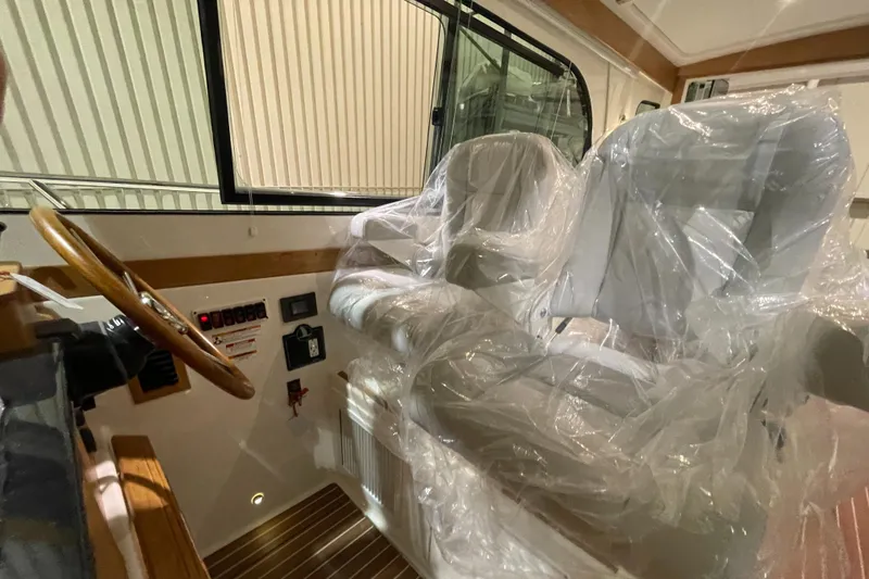 Slide: The Image of 2025 Back Cove 372 boat interior with wrapped seats and wooden steering wheel. - 35