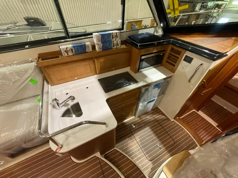 Slide: The Image of 2025 Back Cove 372 yacht kitchen with modern appliances and wood cabinetry. - 37