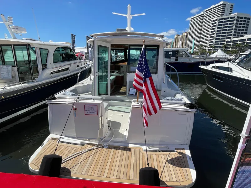 Slide: The Image of 2025 Back Cove 372 yacht docked with American flag, surrounded by other boats. - 4