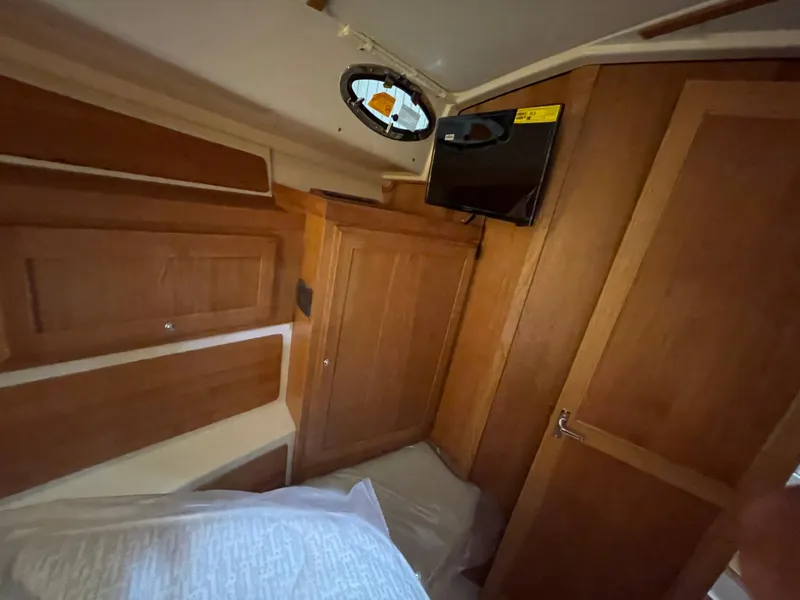 Slide: The Image of Interior cabin of 2025 Back Cove 372 boat with wooden finish and porthole window. - 42