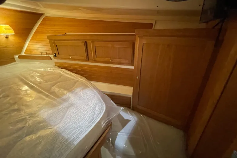 Slide: The Image of 2025 Back Cove 372 cabin interior with wooden cabinetry and bed, showcasing luxury design. - 43