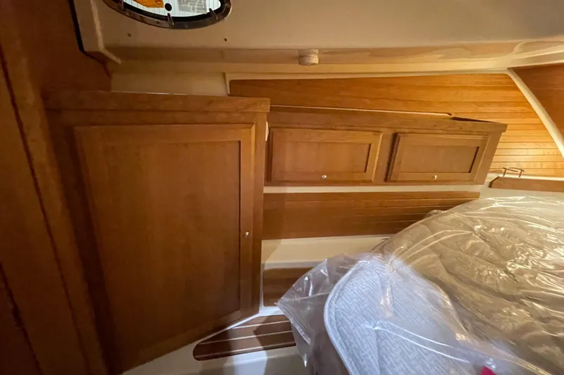 Slide: The Image of 2025 Back Cove 372 interior with wooden cabinets and cozy bedding. - 44