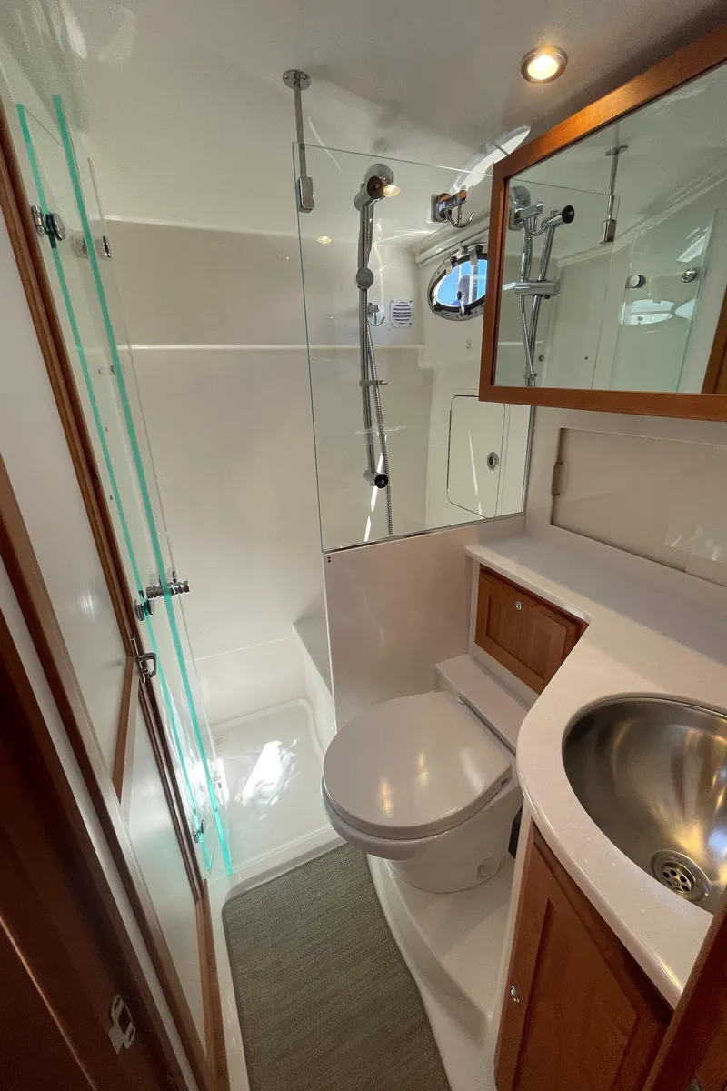 Slide: The Image of 2025 Back Cove 372 yacht bathroom with shower, sink, and wooden cabinetry. - 47