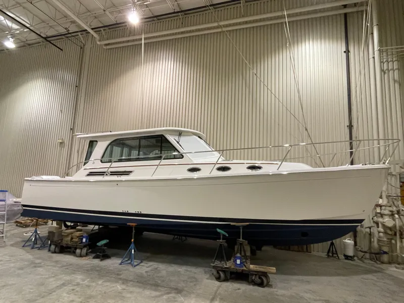 Slide: The Image of 2025 Back Cove 372 boat in a warehouse, elevated on stands, side view. - 5