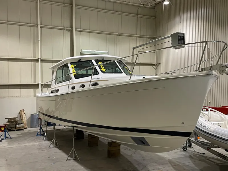 Slide: The Image of 2025 Back Cove 372 boat in a warehouse, elevated on stands, showcasing sleek design. - 8