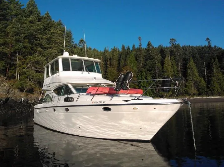 Slide: The Image of 1997 Maxum 4600 Custom SCB yacht anchored near forested shoreline. - 2