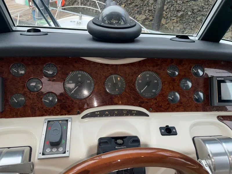 Slide: The Image of 1997 Maxum 4600 Custom SCB dashboard with gauges and controls, featuring wood paneling. - 26