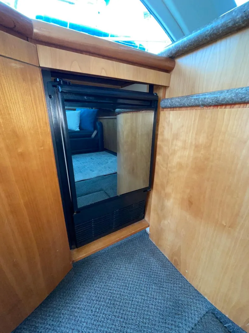 Slide: The Image of 1997 Maxum 4600 Custom SCB yacht interior with compact refrigerator and wooden cabinetry. - 39