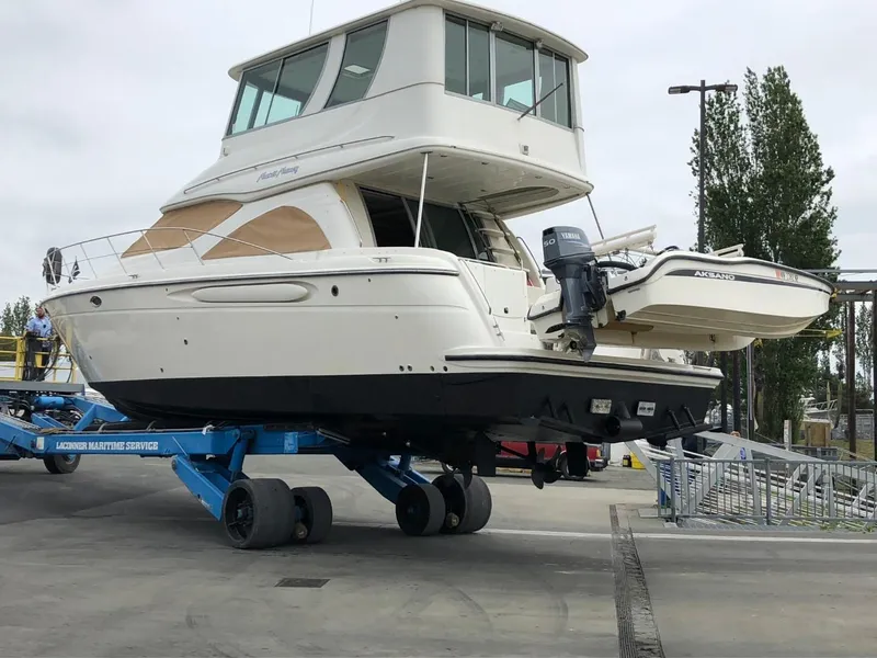Slide: The Image of 1997 Maxum 4600 Custom SCB yacht on a lift at a marina. - 4