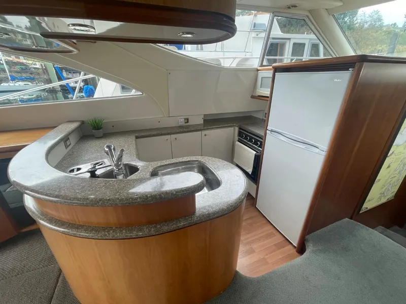 Slide: The Image of 1997 Maxum 4600 Custom SCB yacht kitchen with modern appliances and curved countertops. - 42