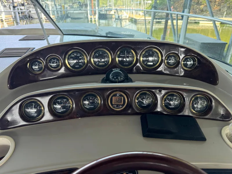 Slide: The Image of Dashboard of 2000 Rinker 330 Fiesta Vee boat with multiple gauges and controls. - 10