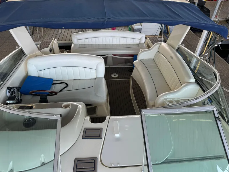 Slide: The Image of 2000 Rinker 330 Fiesta Vee boat interior with white seating and blue canopy. - 16