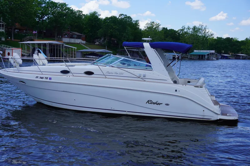 Slide: The Image of 2000 Rinker 330 Fiesta Vee boat on a lake with blue canopy. - 2