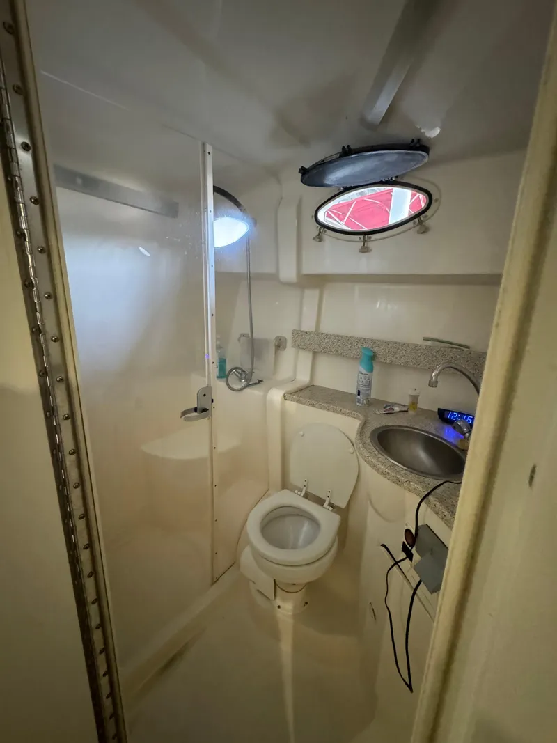 Slide: The Image of 2000 Rinker 330 Fiesta Vee boat bathroom with toilet, sink, and porthole window. - 20
