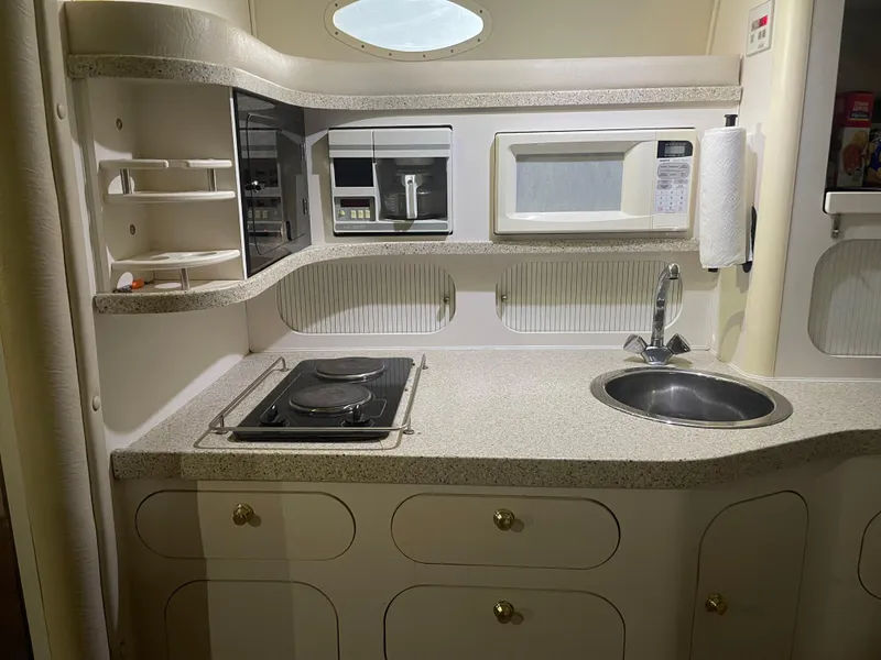 Slide: The Image of Compact kitchen in a 2000 Rinker 330 Fiesta Vee boat with stove and sink. - 24