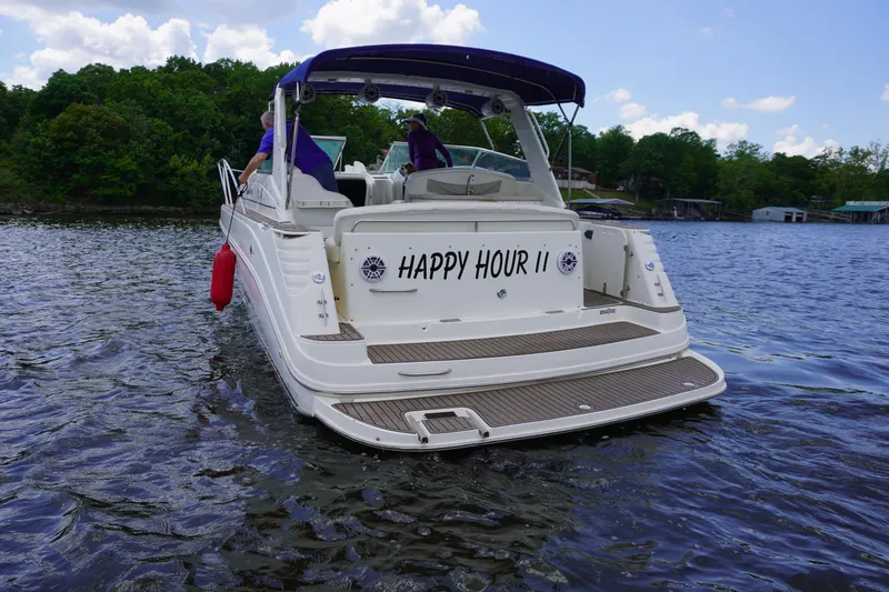 Slide: The Image of 2000 Rinker 330 Fiesta Vee boat named "Happy Hour II" on a lake. - 4