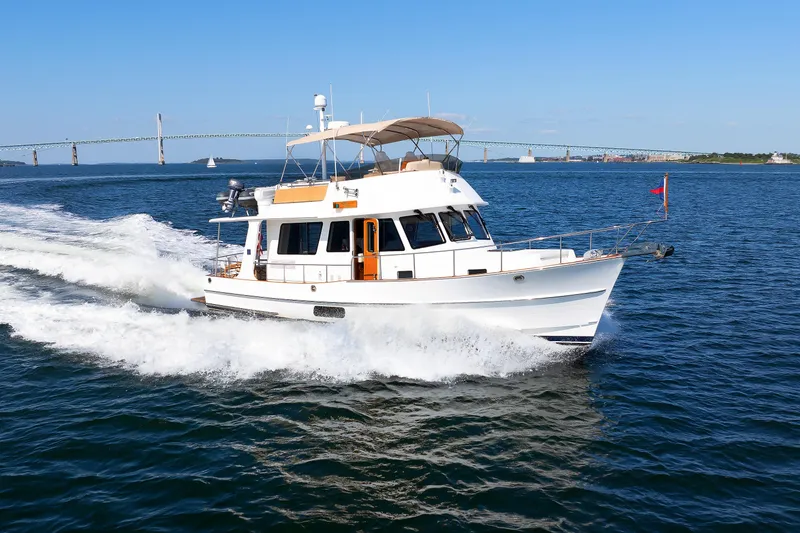 Slide: The Image of 2014 Grand Banks 43 Europa cruising on open water with bridge in background. - 10