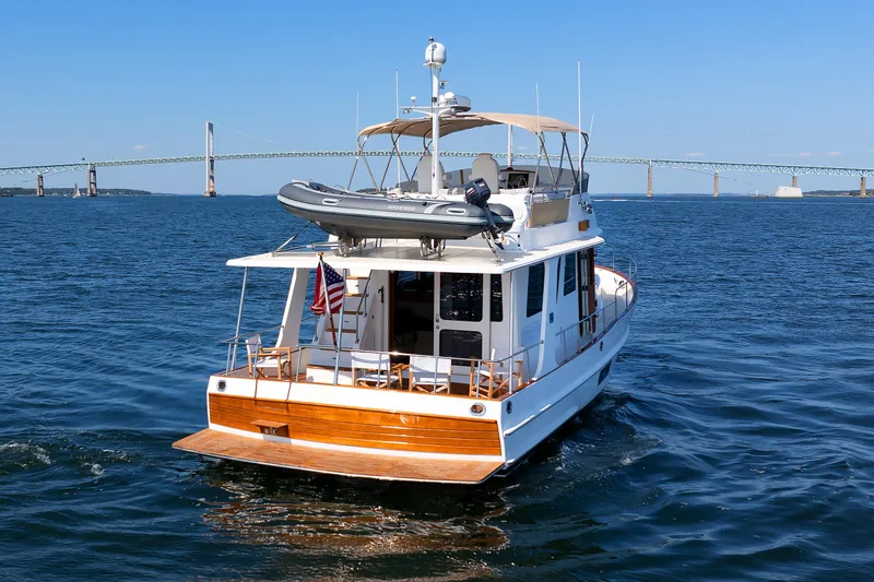 Slide: The Image of 2014 Grand Banks 43 Europa yacht cruising on open water with bridge in background. - 13