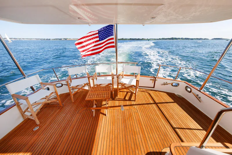 Slide: The Image of Grand Banks 43 Europa 2014 yacht deck with chairs, American flag, ocean view. - 15