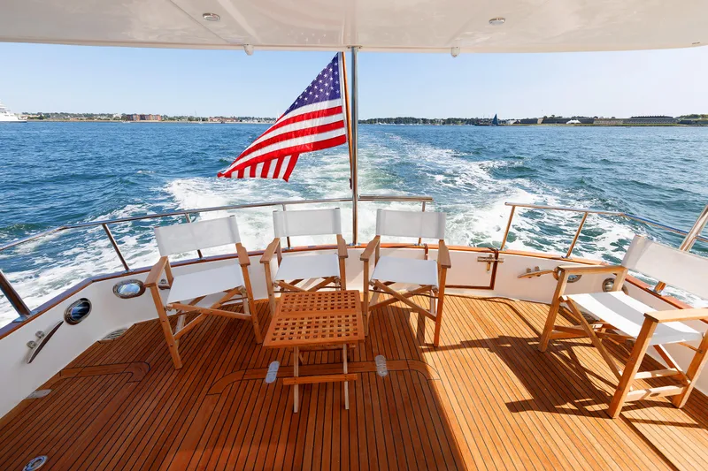 Slide: The Image of Grand Banks 43 Europa 2014 yacht deck with chairs and American flag on open water. - 16
