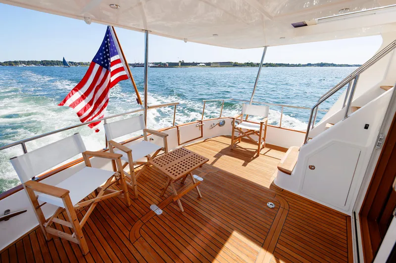 Slide: The Image of Grand Banks 43 Europa 2014 yacht deck with chairs, table, and American flag. - 17