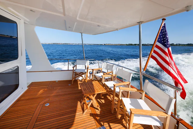 Slide: The Image of Grand Banks 43 Europa 2014 yacht deck with chairs and American flag on open water. - 20