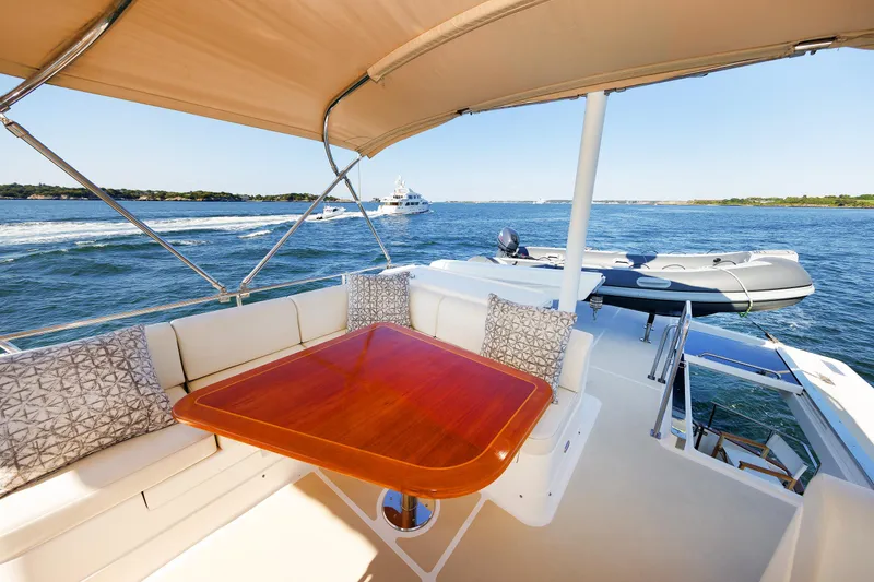 Slide: The Image of Grand Banks 43 Europa 2014 yacht deck with seating and table, overlooking serene waters. - 33