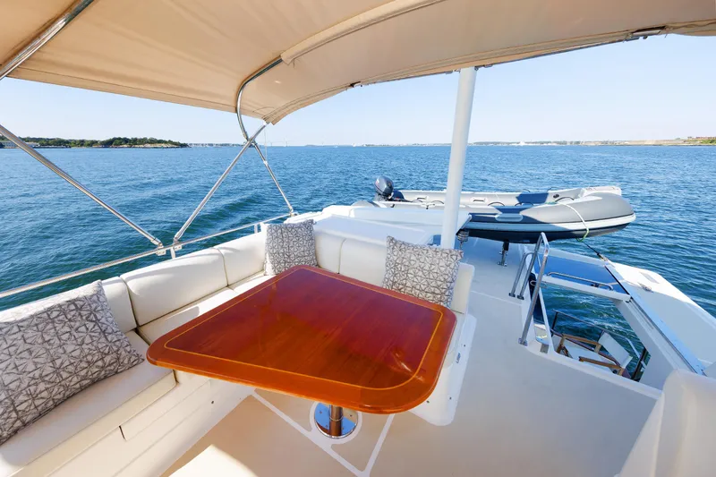 Slide: The Image of 2014 Grand Banks 43 Europa yacht deck with seating and table, overlooking serene ocean view. - 34