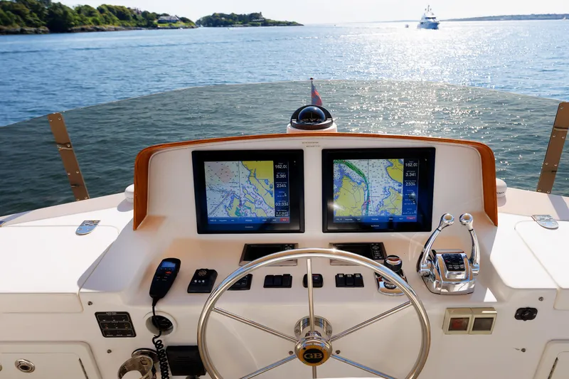 Slide: The Image of Helm of 2014 Grand Banks 43 Europa with dual navigation screens, overlooking serene waters. - 43