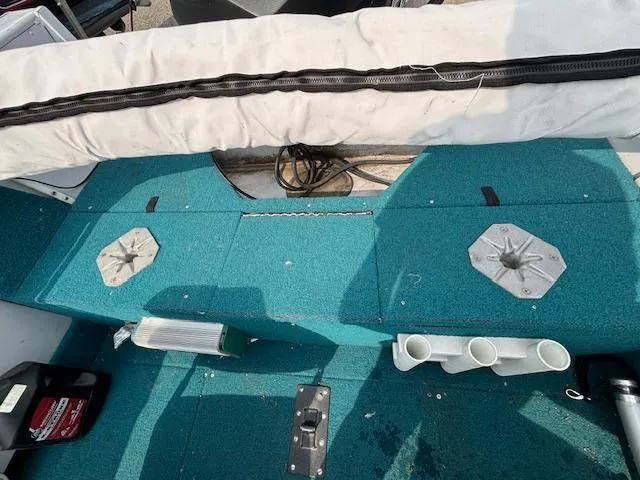 Slide: The Image of Interior of a 1995 Crestliner 1750 SPORT FISH boat with teal carpet and fishing rod holders. - 9