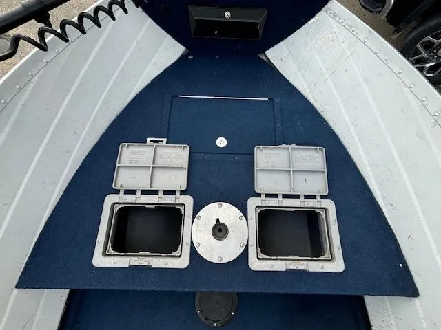 Slide: The Image of 1990 Smoker Craft Resorter boat interior with storage compartments and blue carpet. - 11