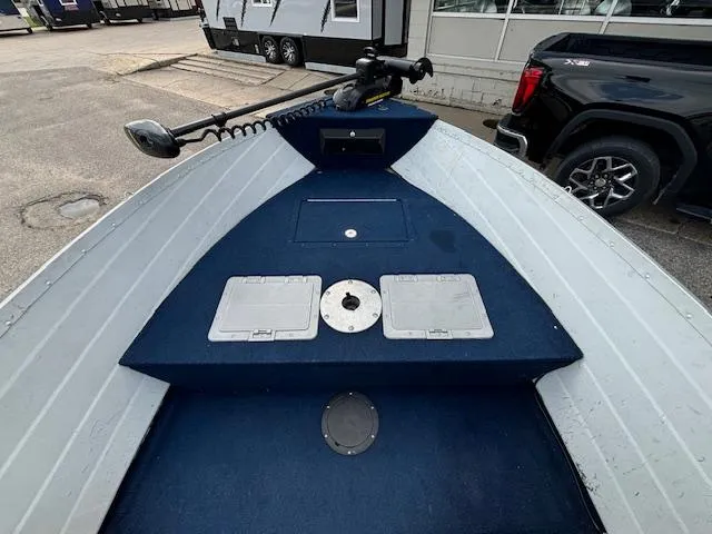 Slide: The Image of 1990 Smoker Craft Resorter boat interior with blue carpet and trolling motor. - 12
