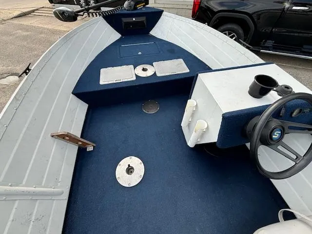Slide: The Image of 1990 Smoker Craft Resorter boat interior with blue carpet and steering console. - 13