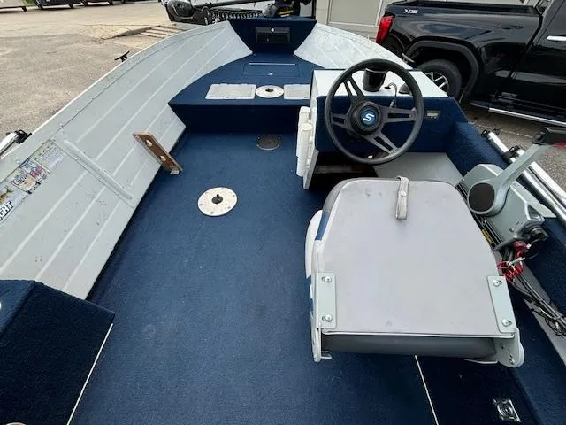 Slide: The Image of 1990 Smoker Craft Resorter boat interior with steering wheel and seating. - 14