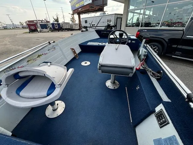 Slide: The Image of 1990 Smoker Craft Resorter boat interior with blue carpet and swivel seats. - 15